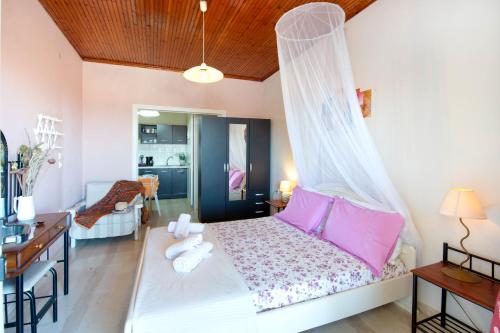 a bedroom with a bed with a mosquito net at Paxos Apartments in Gaios