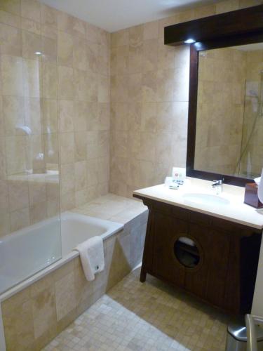a bathroom with a tub and a sink and a bath tub at Les Pagodes de Beauval in Saint-Aignan