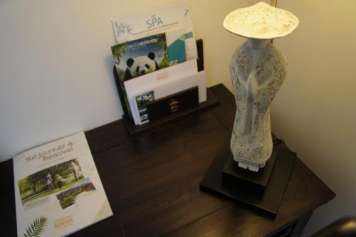 a lamp sitting on a table next to a book at Les Pagodes de Beauval in Saint-Aignan