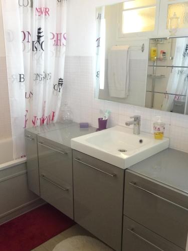 une salle de bain blanche avec un lavabo et un miroir dans l'établissement LES GRANDS CEDRES C1 7 Avenue de Fabron, à Nice