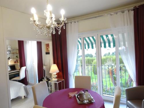 a dining room with a table and a large window at LES GRANDS CEDRES C1 7 Avenue de Fabron in Nice