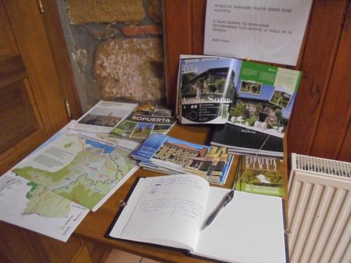 a table with books and maps on top of it at Albergue Areitz Soroa in Arce
