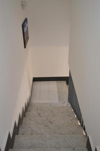 a staircase leading up to a white wall with a tile floor at B&B Casa Di Lauro in Trecase