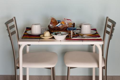 a white table with two chairs and food on it at B&B A CASA DI ZIA LUISA in Venticano