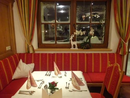 a dining room with a table and a red couch at Naturhotel Hüttenwirt im Grossarltal in Hüttschlag