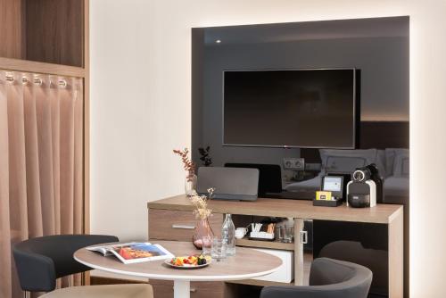 a living room with a table and a television at Melia Madrid Serrano in Madrid