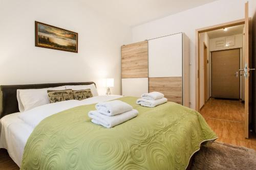 um quarto com uma cama grande e toalhas em Corvin 4 Sun Resort Apartment em Budapeste