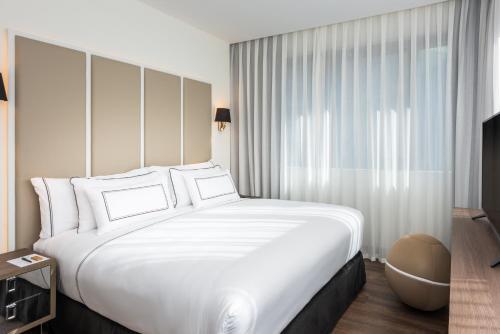 a large white bed in a hotel room at Melia Madrid Serrano in Madrid