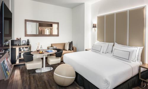 a hotel room with a large bed and a living room at Melia Madrid Serrano in Madrid