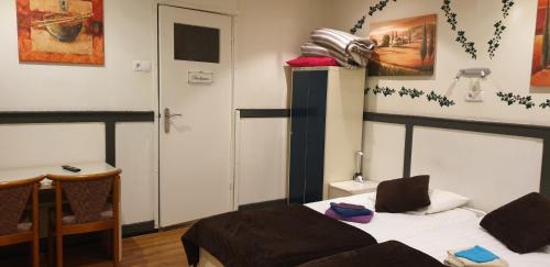 a room with a bed and a table and a door at De Zevende Hemel in Kerkrade