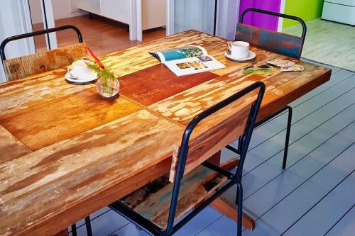 a wooden table with two chairs and a wooden table with at Rusty Pelican - "Goofy Gecko" Container Apt. in La Gaulette