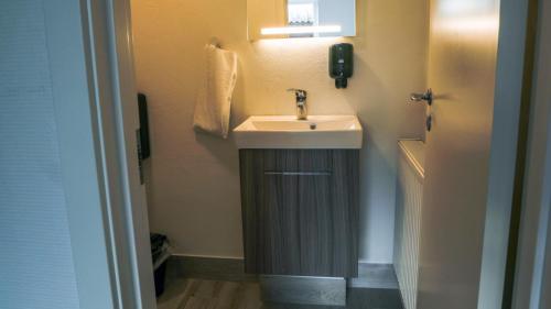 a small bathroom with a sink and a mirror at B&B by the Sea Hirtshals in Hirtshals