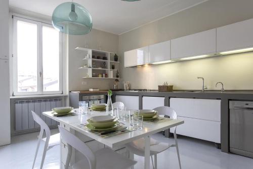 a kitchen with a white table with chairs and a sink at Casa ALBERTINI in Como