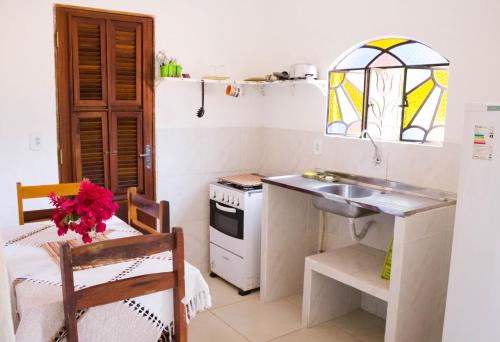 a small kitchen with a sink and a counter top at Pousada Morada do Sol in Canoa Quebrada