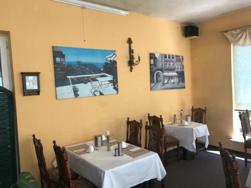a dining room with two tables in a restaurant at Hotel Gasthof Goldener Hahn in Frankfurt/Oder