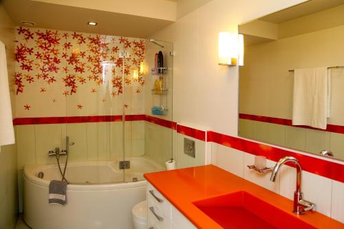 a bathroom with a tub and a toilet and a sink at The Villa of the Winds in Néa Kíos