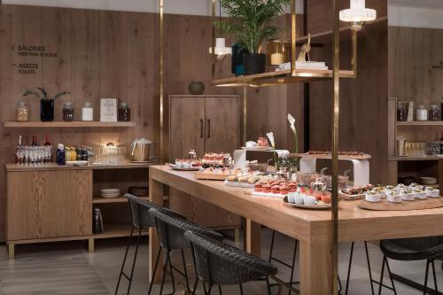 a long table with food on it in a restaurant at Melia Madrid Serrano in Madrid