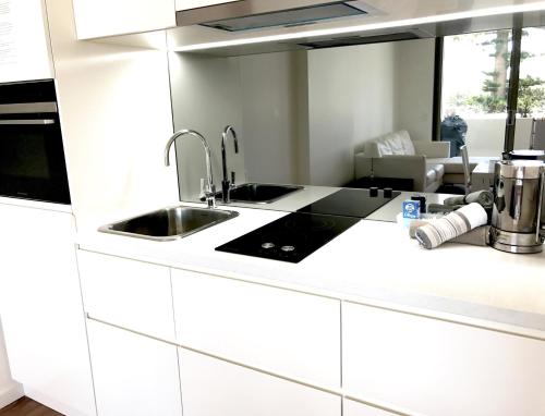 a white kitchen with a sink and a stove at Kiama Executive in Kiama
