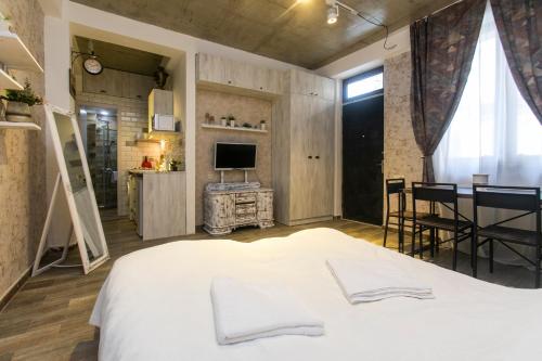sypialnia z dużym białym łóżkiem i kuchnią w obiekcie Apartment N 40 w mieście Tbilisi City