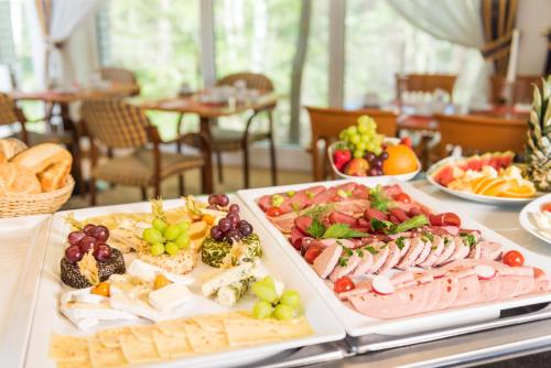 ein Tisch mit zwei Tabletts mit verschiedenen Arten von Lebensmitteln in der Unterkunft Bel Air Strandhotel Glowe in Glowe