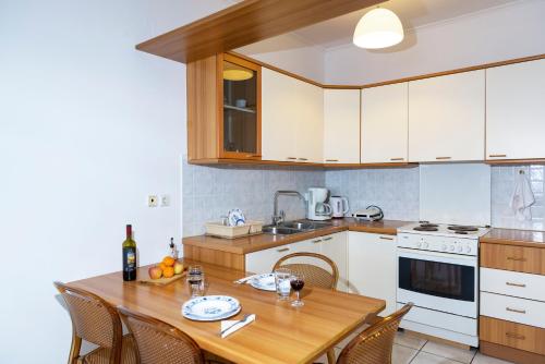 kuchnia z drewnianym stołem i kuchnia z białymi urządzeniami w obiekcie Sunrise Beachfront Apartment w mieście Sitia