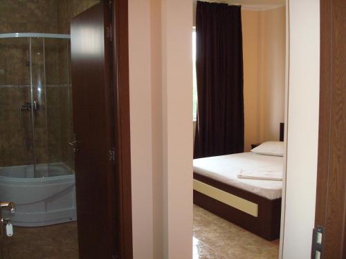 a bathroom with a shower and a bed and a tub at Casa Alex in Eforie Nord