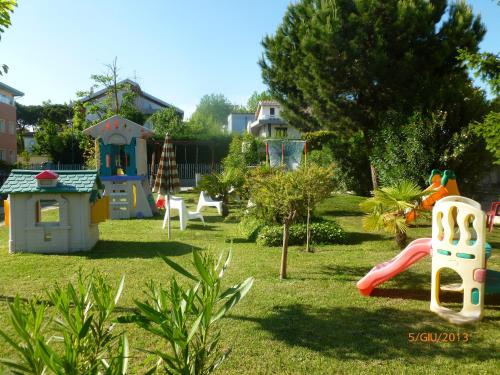 a garden with a playground with play equipment in the grass at Villa Liliana in Cervia
