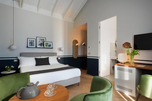 una camera d'albergo con letto, scrivania e sedie di Velvet Grey Boutique Hotel a Milano