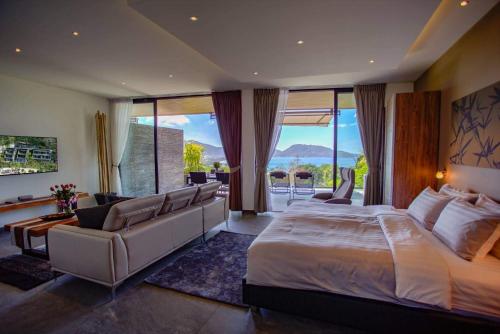 a bedroom with a large bed and a large window at Ocean Rock Kalim in Patong Beach