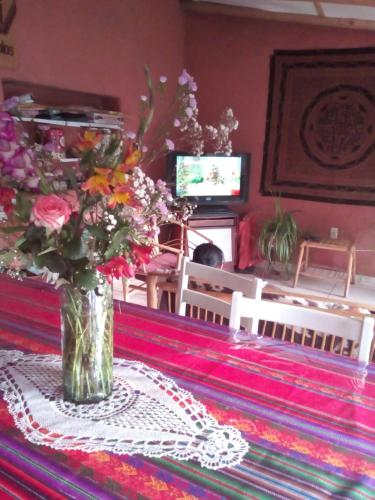a vase filled with flowers sitting on a table at Wayqi Wasi in Pisac