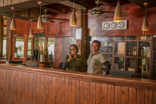 two women standing behind a counter in a bar at Nkambeni Safari Camp in Hazyview