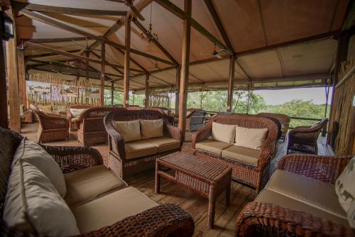 a room with wicker chairs and furniture on a train at Nkambeni Safari Camp in Hazyview