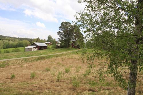 an open field with a barn and a road at Åsen in Årjäng