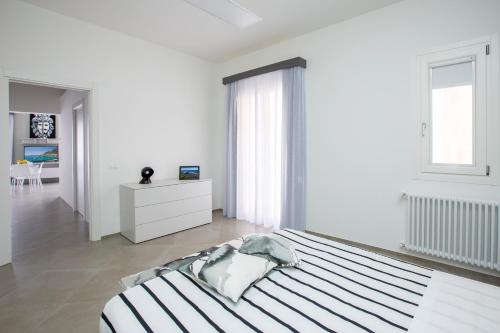 a white bedroom with a large bed and a window at Le Cupole Suites & Apartments in Trapani