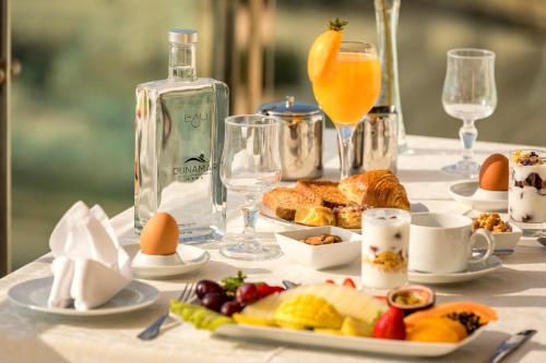 a table with breakfast foods and a bottle of orange juice at Hotel Apartamento Dunamar in Monte Gordo
