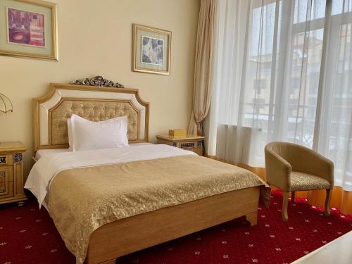 a bedroom with a bed and a chair and a window at Visak Hotel in Kyiv