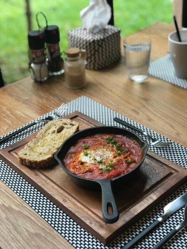 a table with a bowl of food and a plate of bread at The Ryad Rayong in Mae Pim