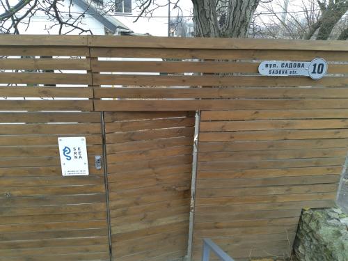 a wooden fence with a street sign on it at Guest House Serena in Chornomorsk