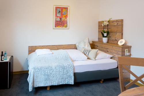 Schlafzimmer mit einem Bett mit einem Kopfteil aus Holz in der Unterkunft Pension Domblick in Wetzlar