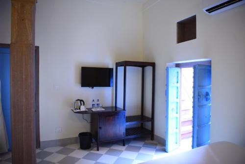 a room with a mirror and a desk and a television at Baijoo Niwas in Jodhpur