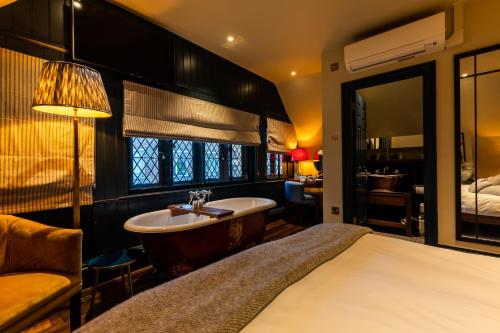 a bedroom with a bath tub and a bed at Fox and Anchor in London