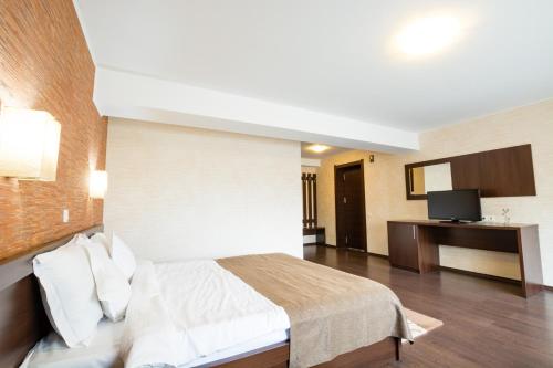 a hotel room with a bed and a television at Vila Hera Luxury in Predeal