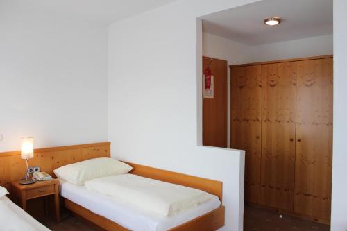 a small bedroom with a bed and a nightstand and a bed sidx sidx sidx at Hotel-Restaurant Faustschlössl in Feldkirchen an der Donau