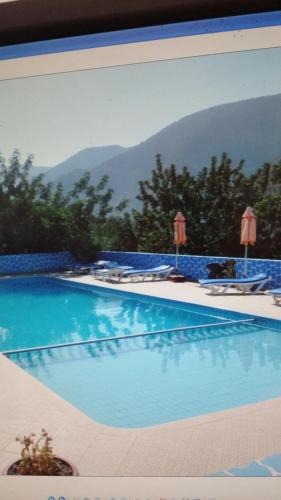 a picture of a swimming pool with mountains in the background at Auberge BAB IMOUZER in Tagherat Anekrim