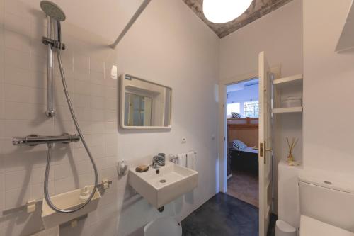 Un baño blanco con lavabo y ducha. en Loft with love in Pals, en Pals