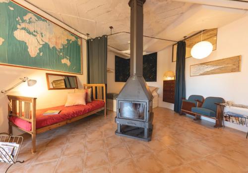 sala de estar con estufa de leña y sofá en Loft with love in Pals, en Pals