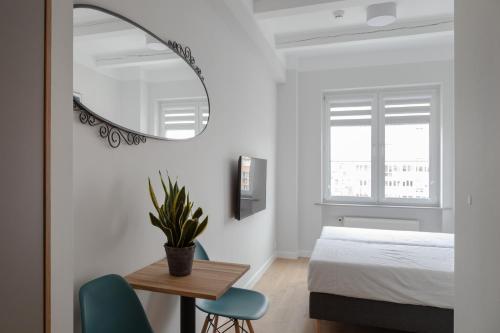 a bedroom with a bed and a table and a mirror at MoHo XL in Wrocław