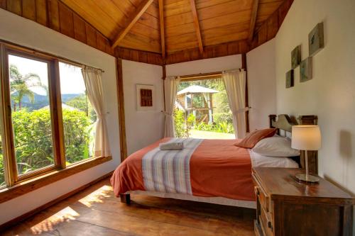 a bedroom with a bed and a large window at Terrabambu Lodge in Mindo