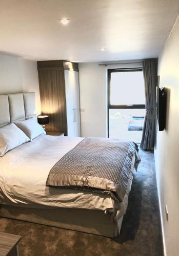 een slaapkamer met een groot bed en een groot raam bij Millstream Mews in Bakewell