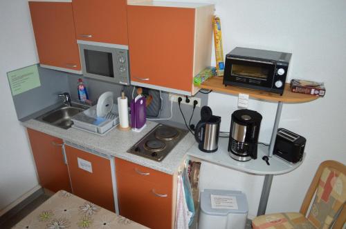 a small kitchen with a sink and a microwave at Pension Tiffany in Chemnitz